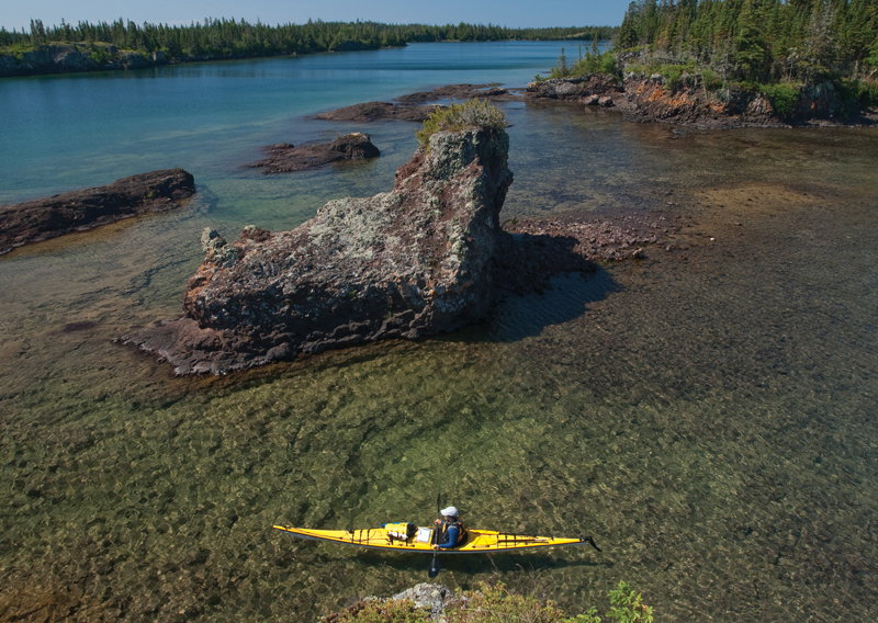 A kayaker explores the rugged shoreline of Lake Superior at Isle Royale National Park.