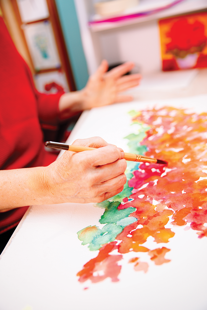 Gifted artist Mary Lou Peters works on a new geranium painting that will feature several pots.